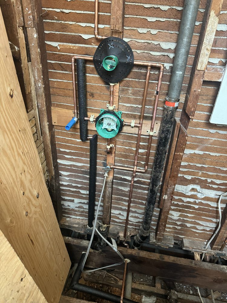 Clean copper repiping and pressure regulator installation behind an open wall